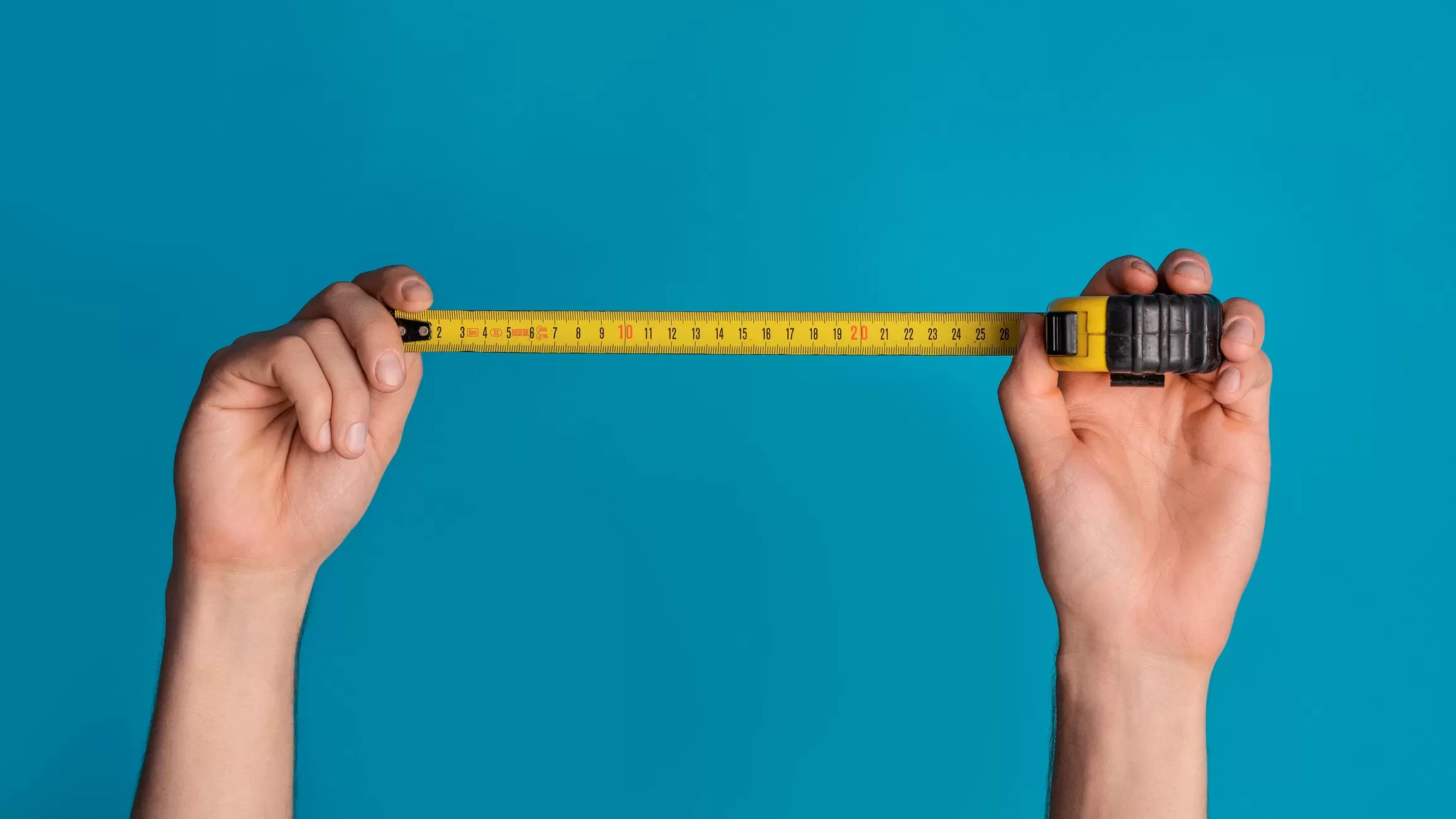 House renovation Unrecognizable repairman holding tape measure on blue background closeup Panorama